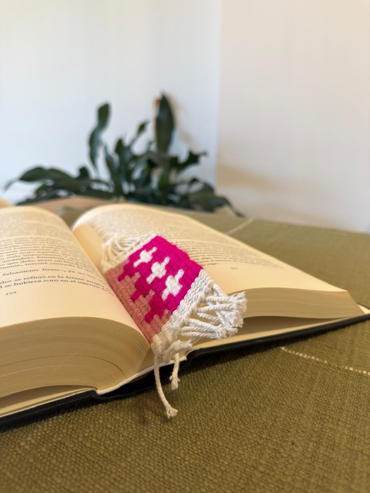 Open book with a colorful bookmark on a green surface
