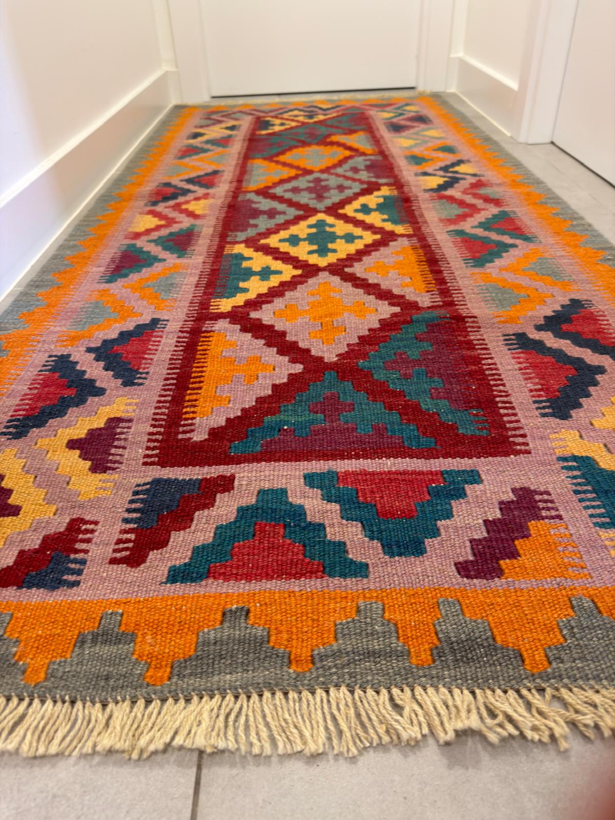 Colorful geometric patterned rug on a tiled floor