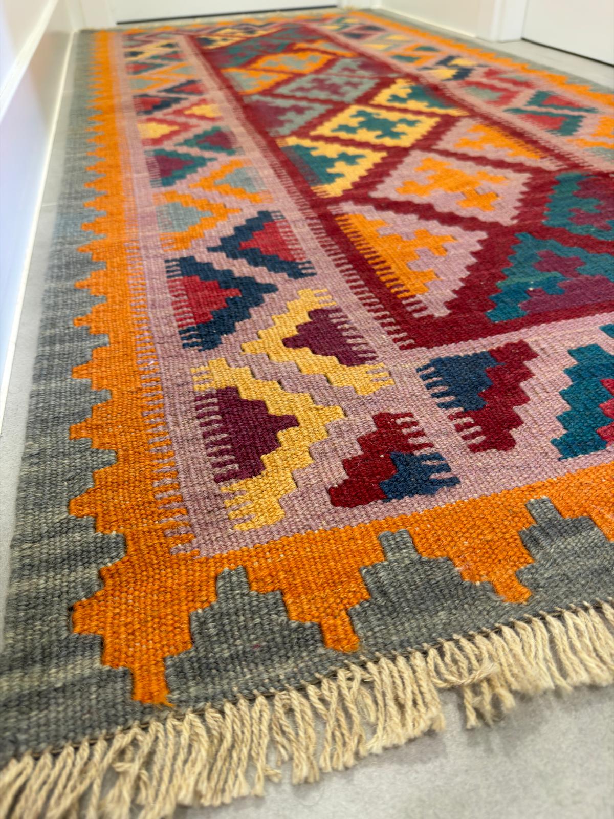 Colorful patterned rug with geometric design on a plain background