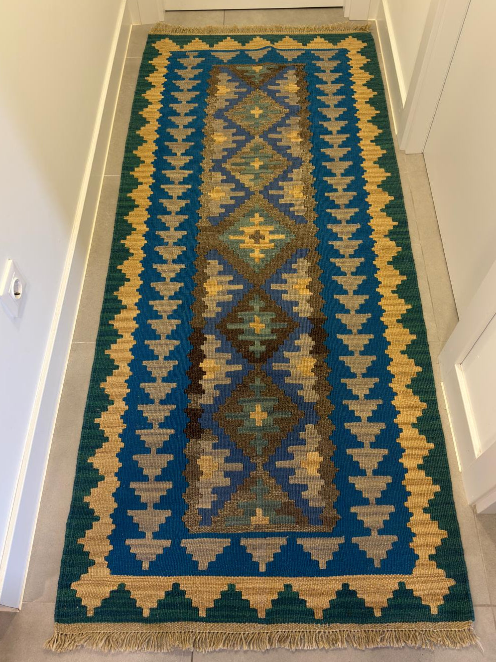 Decorative rug with geometric pattern on a hallway floor