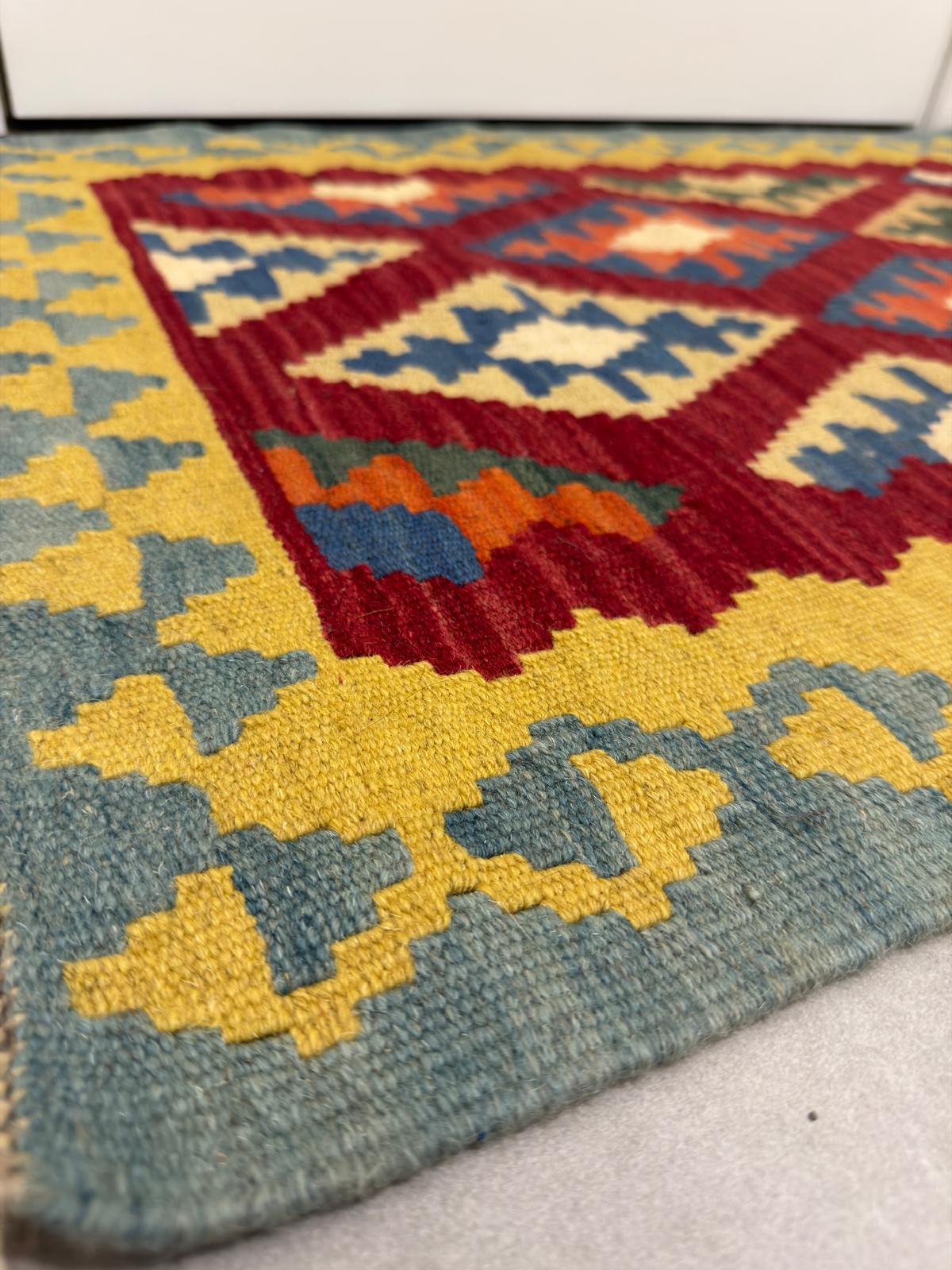 Colorful geometric patterned rug with red, blue, yellow, and green colors.