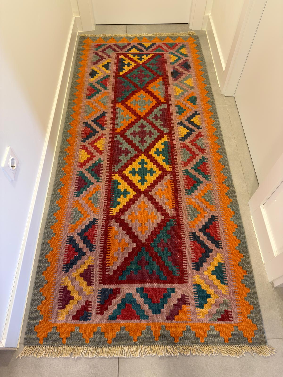 Colorful patterned natural rug on a gray floor