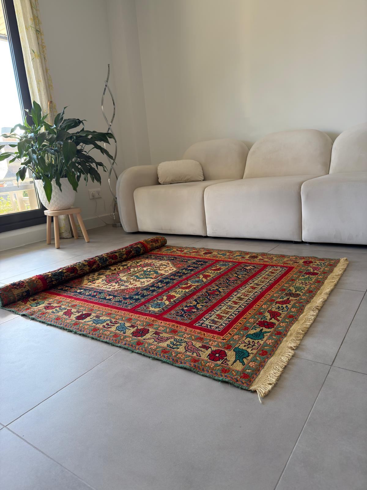 Decorative rug with intricate patterns on a tiled floor in a living room.