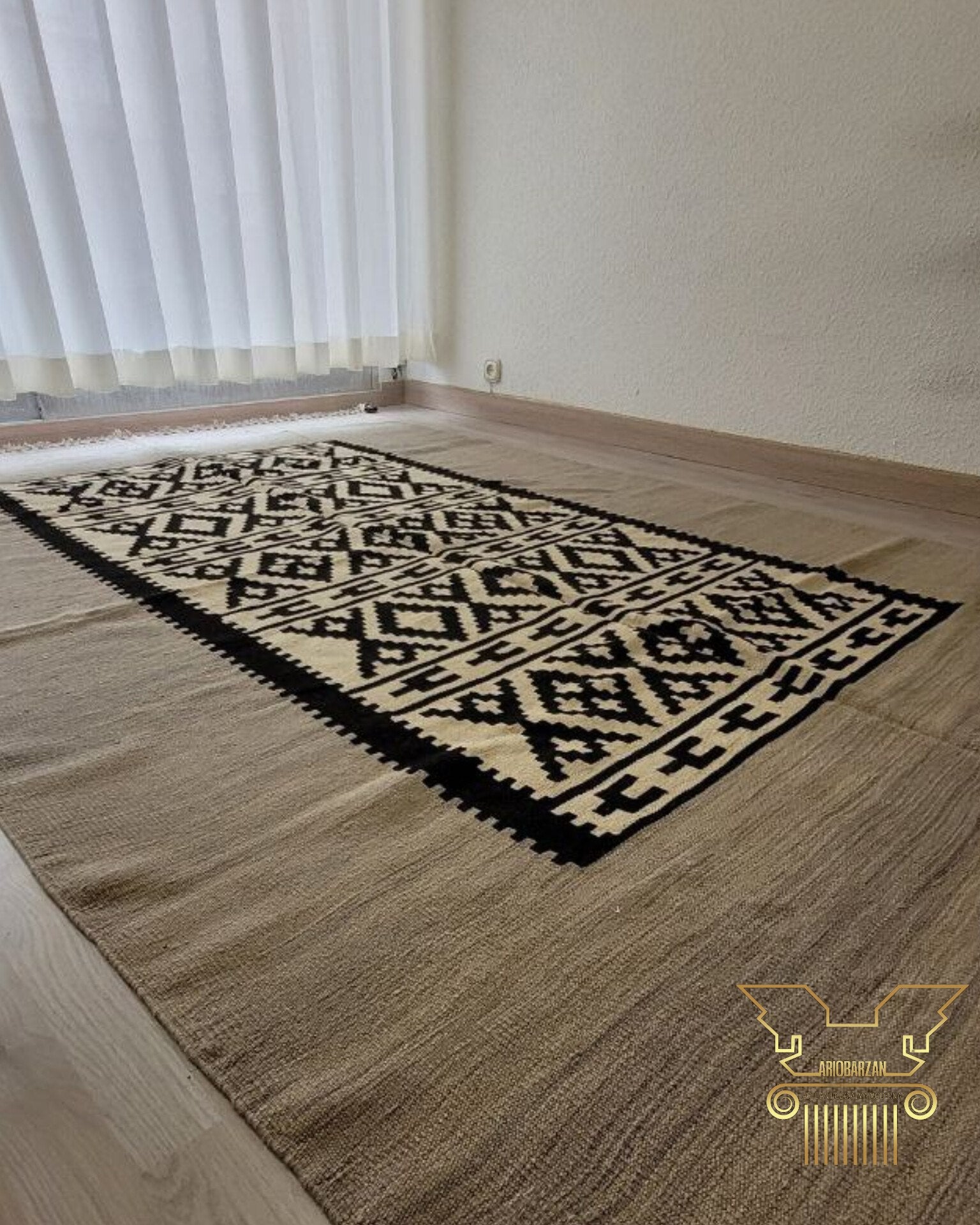 Patterned rug on a wooden floor with a window in the background