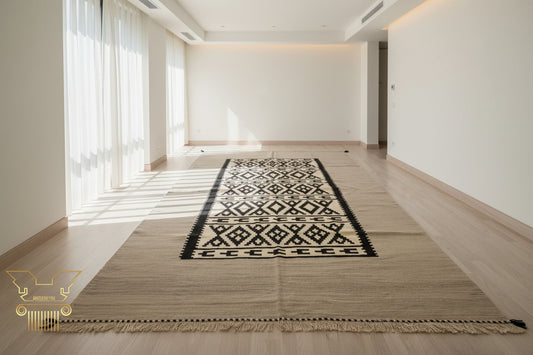 Beige rug with black geometric pattern on a wooden floor